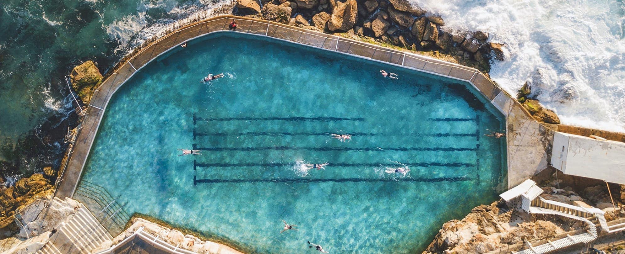 Bird's eye view of outdoor lap pool surrounded by the ocean 